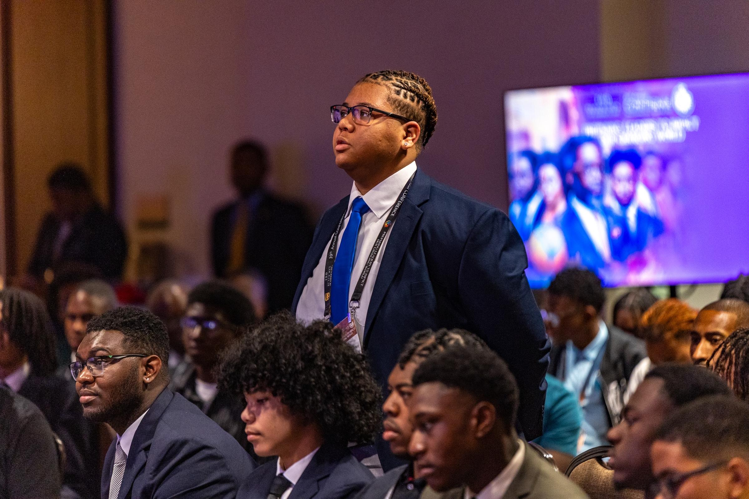 Student stands to speak during youth leadership workshop session.