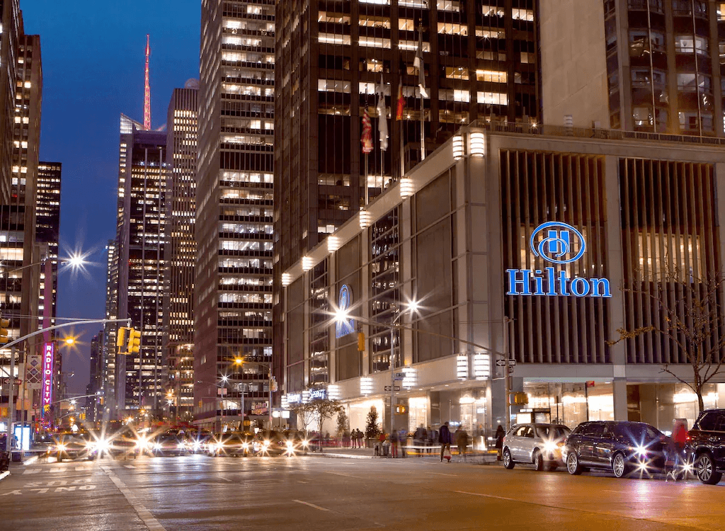 Hilton hotel exterior at night in Midtown Manhattan with city lights and traffic