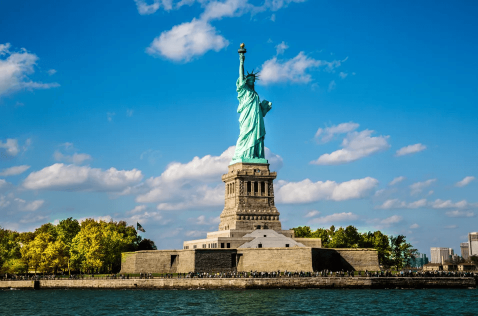 Statue of Liberty on Liberty Island under blue sky and clouds